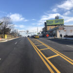 Ground level image of new new asphalt, striping and sidewalks on Belair Road