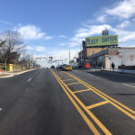 Ground level new new asphalt, striping and sidewalks on Belair Road