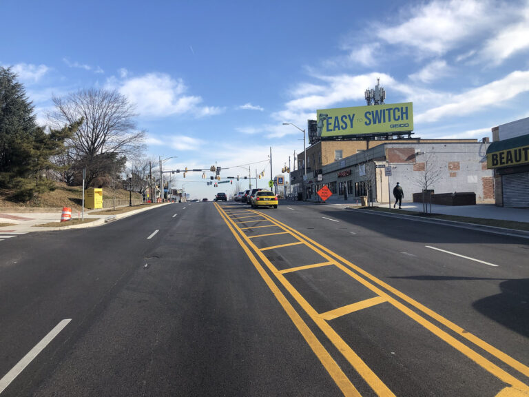 Ground level image of new new asphalt, striping and sidewalks on Belair Road