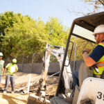 Flanigan crew using a mini excavator to level sand for storm water management